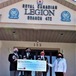 Trois personnes représentant la Légion canadienne et les Dames auxiliaires remettent un chèque géant à la représentante de la Fondation HGH.