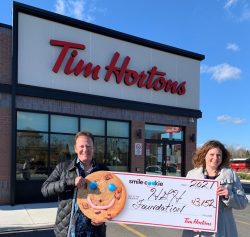 Paul Burke, propriétaire des restaurants locaux Tim Hortons, remet un chèque géant à Erin Tabakman, directrice générale de la Fondation HGH.