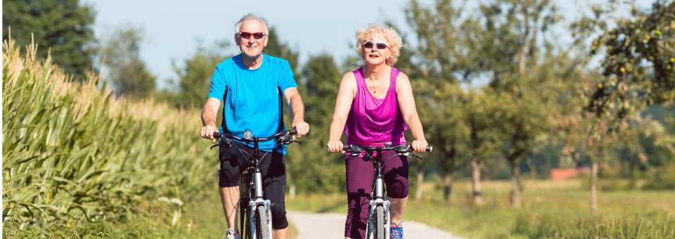 Homme et femme dans la soixantaine font du vélo en plein air